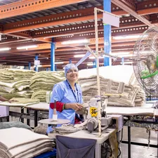 Workers sew fabric at a factory production line. related to The Rise of Natural Bed Companies: Embracing Eco-Friendly Sleep Solutions