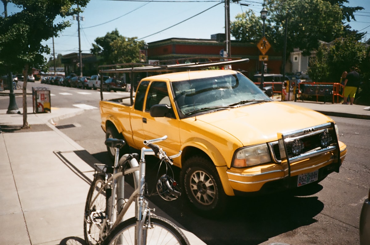 yellow extra cab pickup truck on road near bike parking during daytime related to The Ultimate Guide to Choosing the Best Bike Racks for Truck Beds