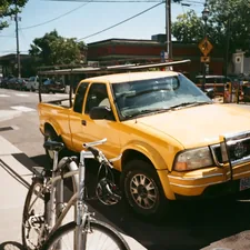yellow extra cab pickup truck on road near bike parking during daytime related to The Ultimate Guide to Choosing the Best Bike Racks for Truck Beds