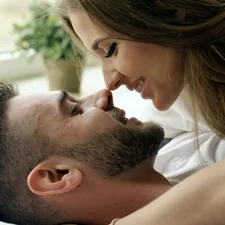 Young beautiful and loving couple wake up at morning. Attractive man kiss and hug his wife in bed related to Exploring the Differences: Men and Women in Bed