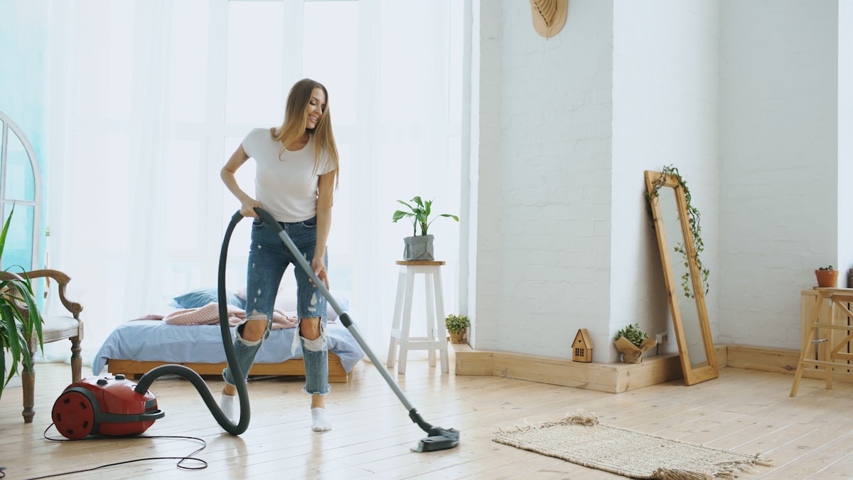 Young woman having fun cleaning house with vacuum cleaner dancing and singing related to The Ultimate Guide to Bed Bath and Beyond Vacuum Cleaners